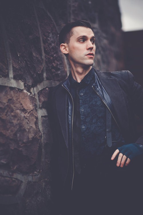 Jamie Benson looks dapper posing next to a stone wall