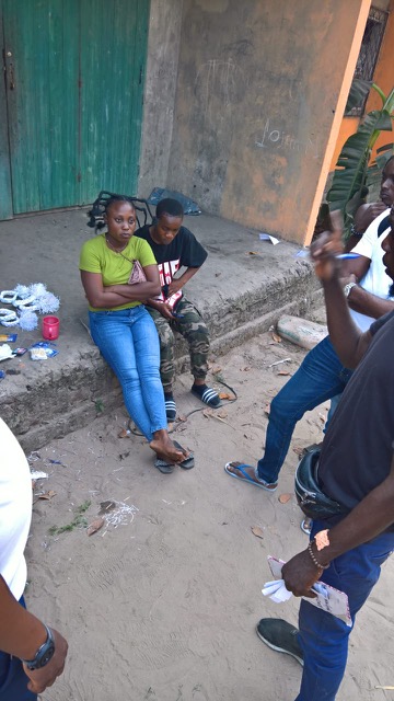 dancers in jeans and khaki's sitting outside on the steps of the theater in Brazzaville, it is a very poor town