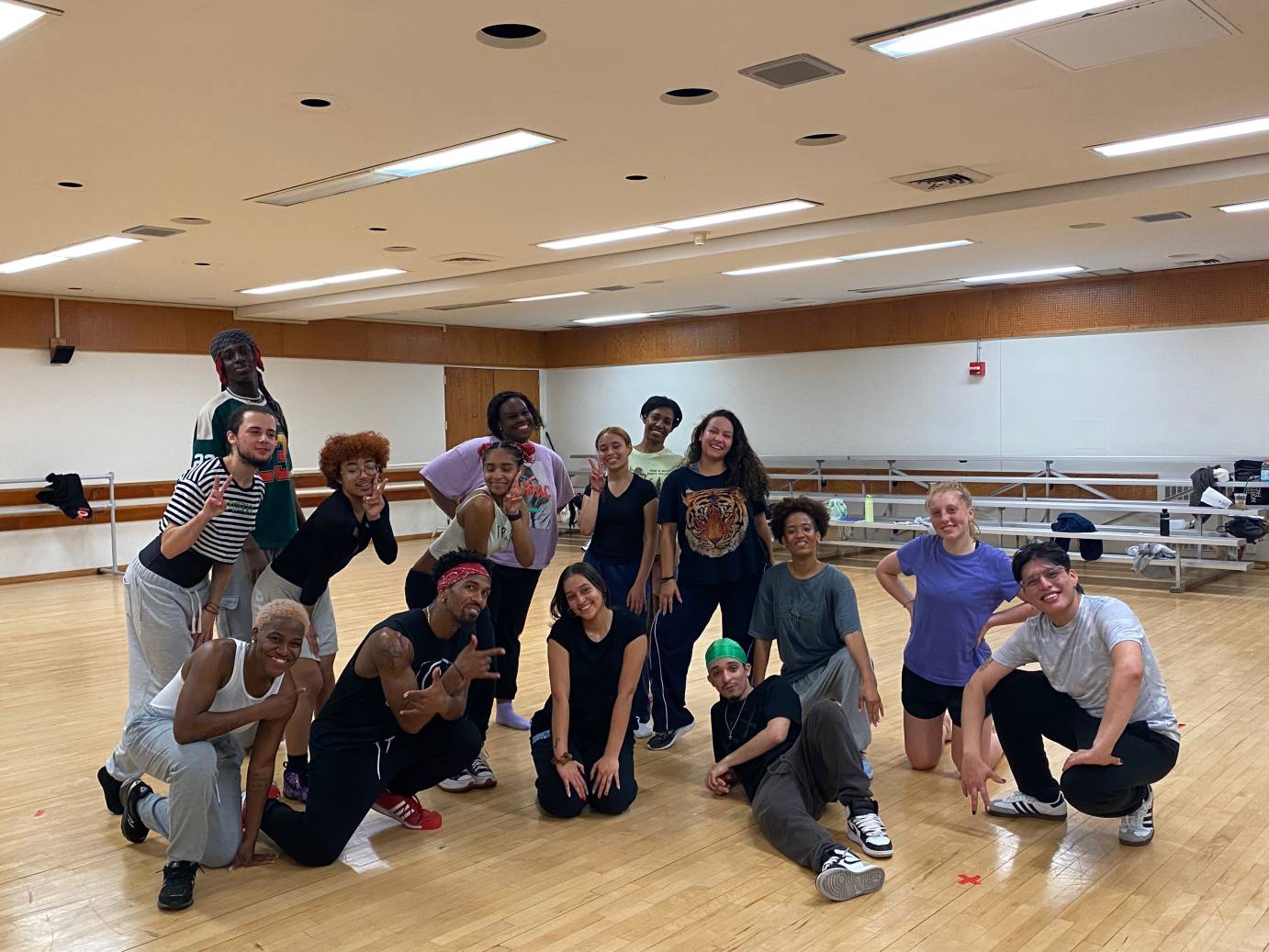 A group of dancers kneel and stand for a family dance class portrait.