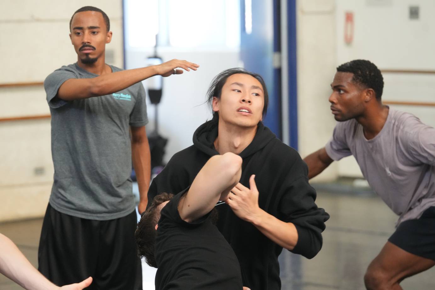 Dancers in rehearsal clothes all assume different emotional states ina photo caught during rehearsal 