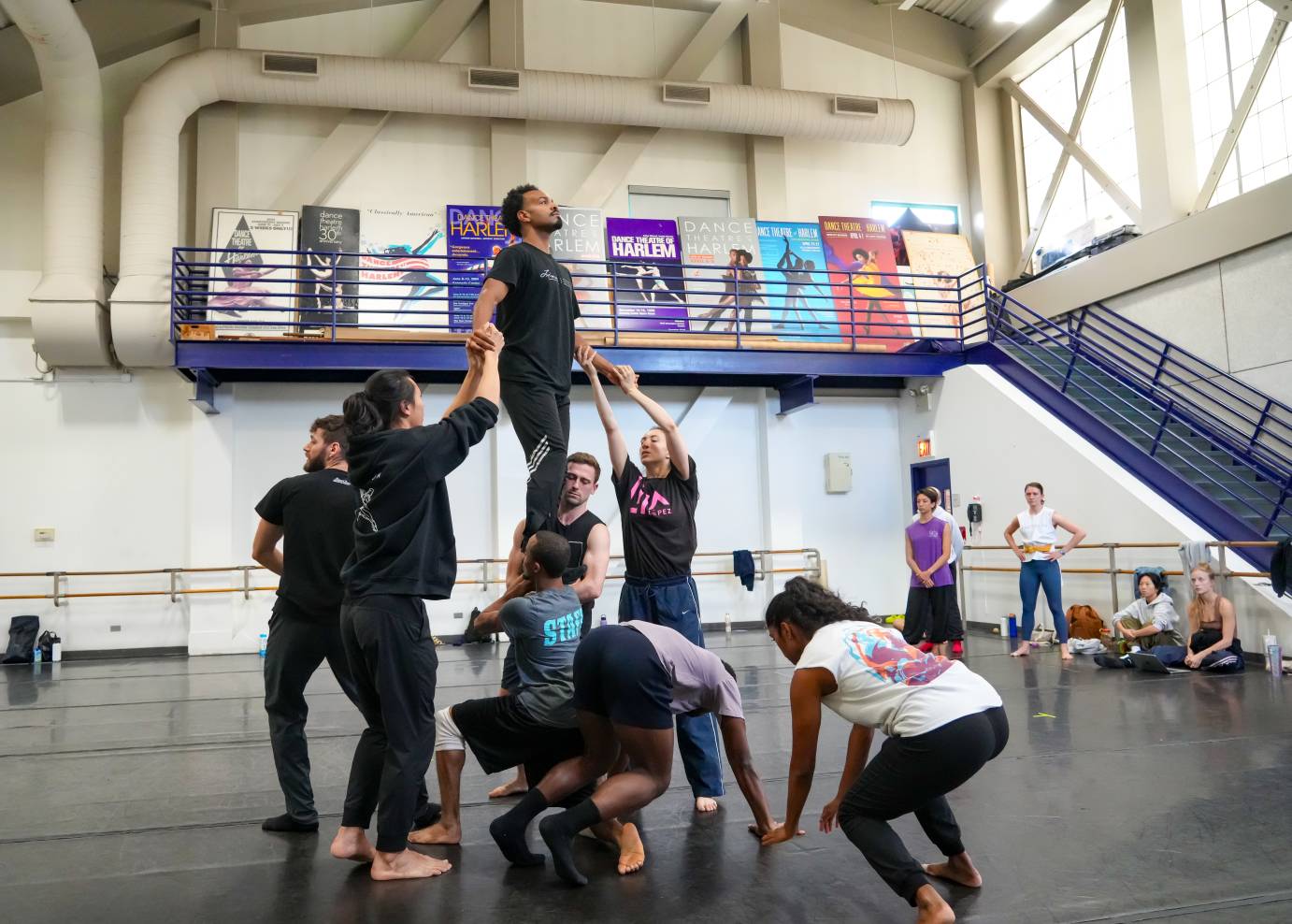 an interesting view from below  of the Eric's walk across his castmates body...we can see how high the studio ceilings are and can see the large posters of Dance Theatre of Harlem's ballets in the back  