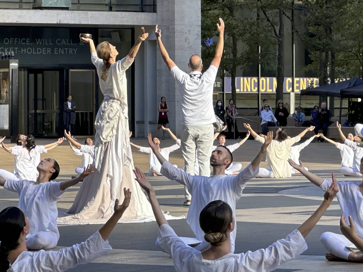 more members of the cast and musicians lifting their arms toward the sky