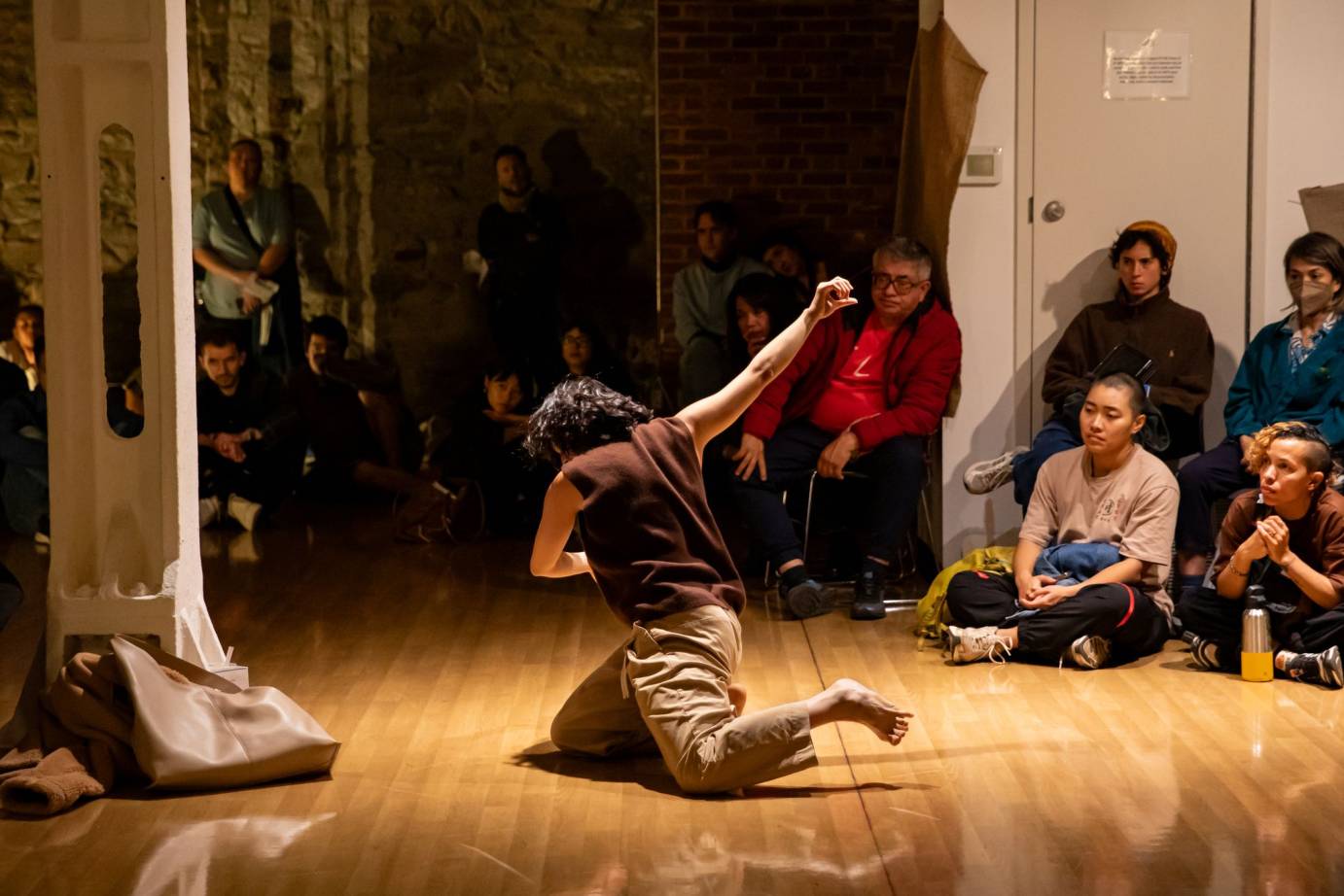 the dancer is on her knees looking as if she just hurled herself into that position  one arm reaches high to the cieling ... we are only viwing her from the back 